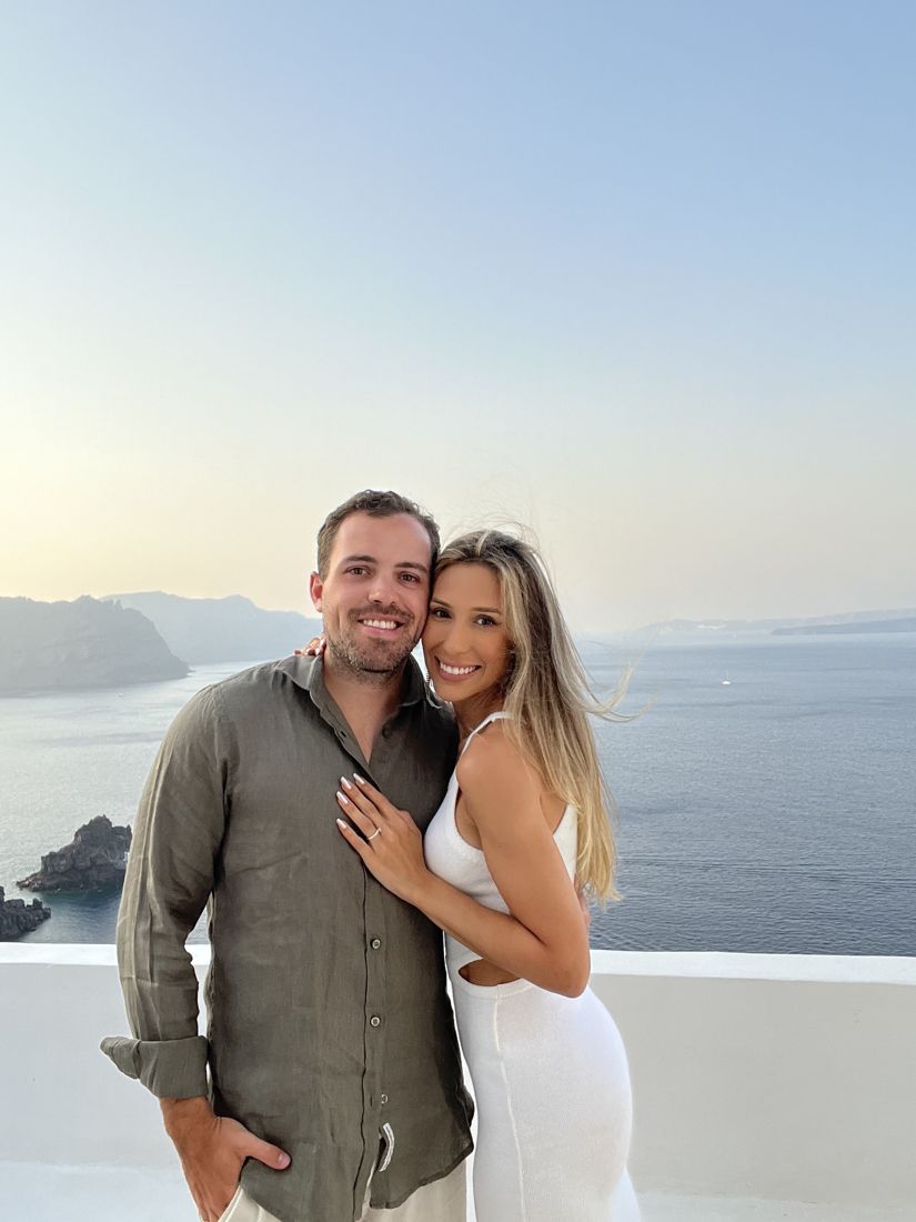 Paula e Francisco ao pôr do sol no mar Egeu, ela mostrando o anel